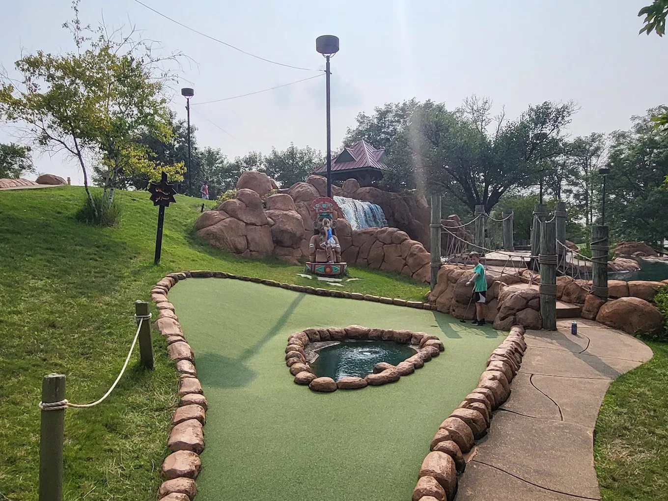 Aztec-style totem statue overlooking a mini golf hole