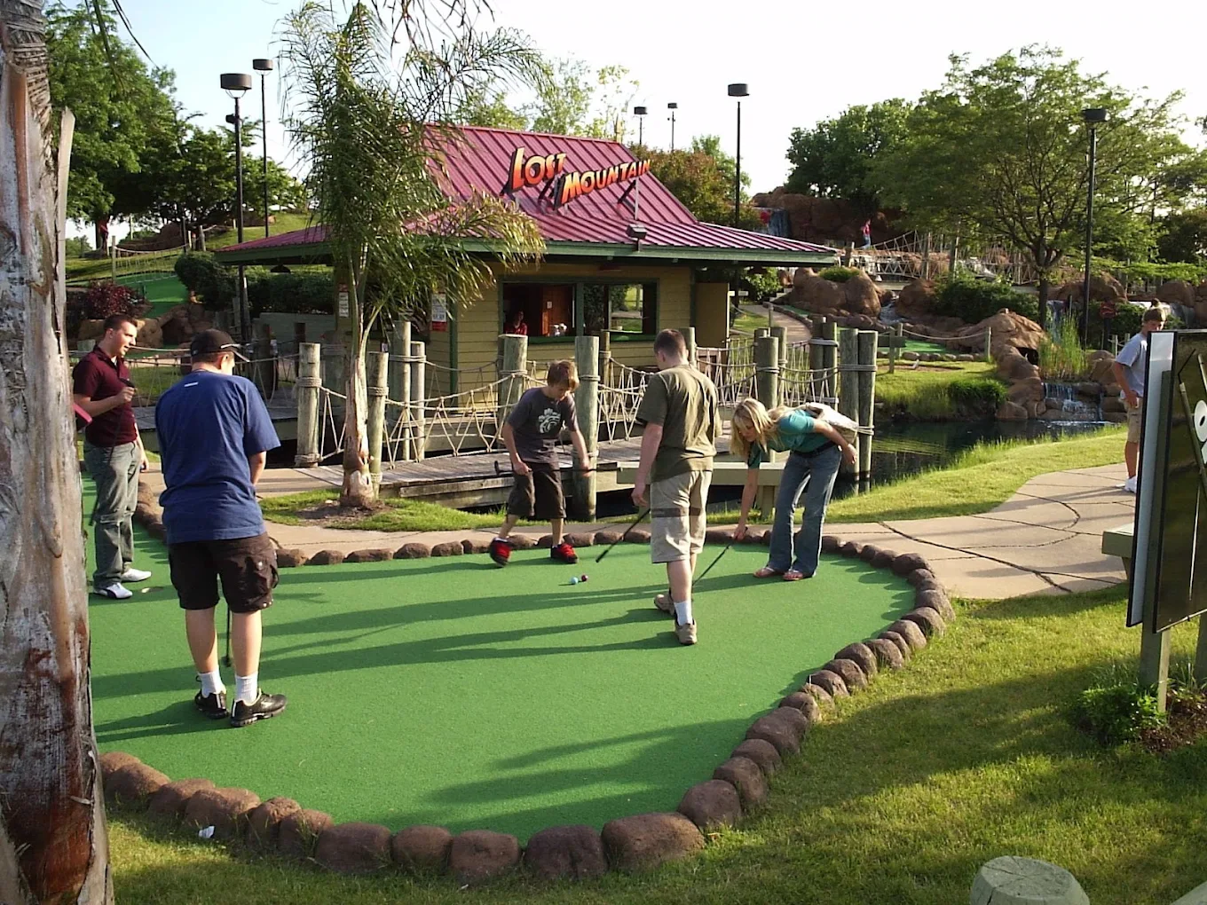 Lost Mountain Adventure Golf clubhouse with red roof, palm trees, and putting greens